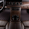Interior view of a car showing leather seats, wood trim, and an automatic climate control panel.
