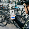 Eine Person hält ein Smartphone, das an einem Fahrrad befestigt ist, um Fahrräder zu verfolgen.