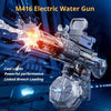 Close-up of an M416 electric water gun firing a stream of water and mist against a dark blue background.