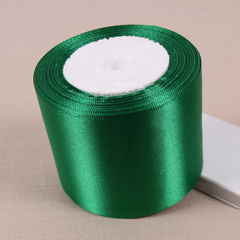 A roll of emerald green lustrous satin ribbon for gift wrapping and crafts.