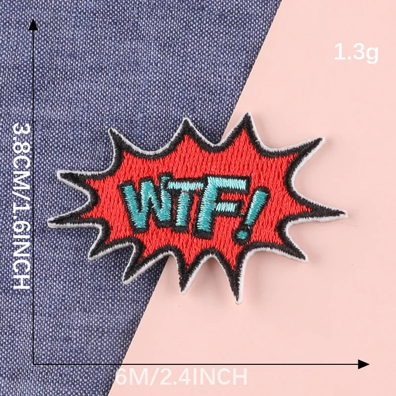 An embroidered patch with the text WTF in teal thread on a red background is shown against a blue fabric.