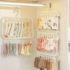 A white laundry drying rack with multiple hanging clips holding various colored and patterned garments.