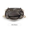 A small black clutch bag with gold metal hardware shown from above.