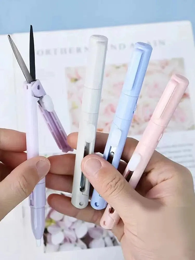 A hand holds several mini pen-shaped scissors and cutters in various pastel colors against a blurred background.