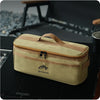 A beige portable storage bag for camping tableware with a brown trim, resting on a dark surface.