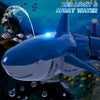 A blue shark toy is shown spraying water, with small bubbles visible in the background.