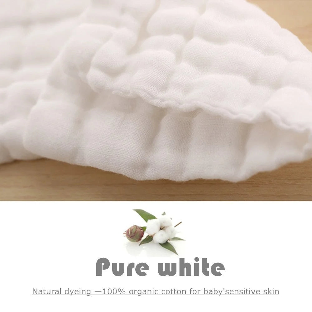 A close-up of white, quilted organic cotton washcloths with a natural dye detail.