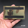 A rectangular tactical patch featuring a national flag design in camouflage colors with a crest and hook-and-loop backing.