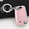 A pink TPU car key cover with a silver keyring attached, shown against a dark background.