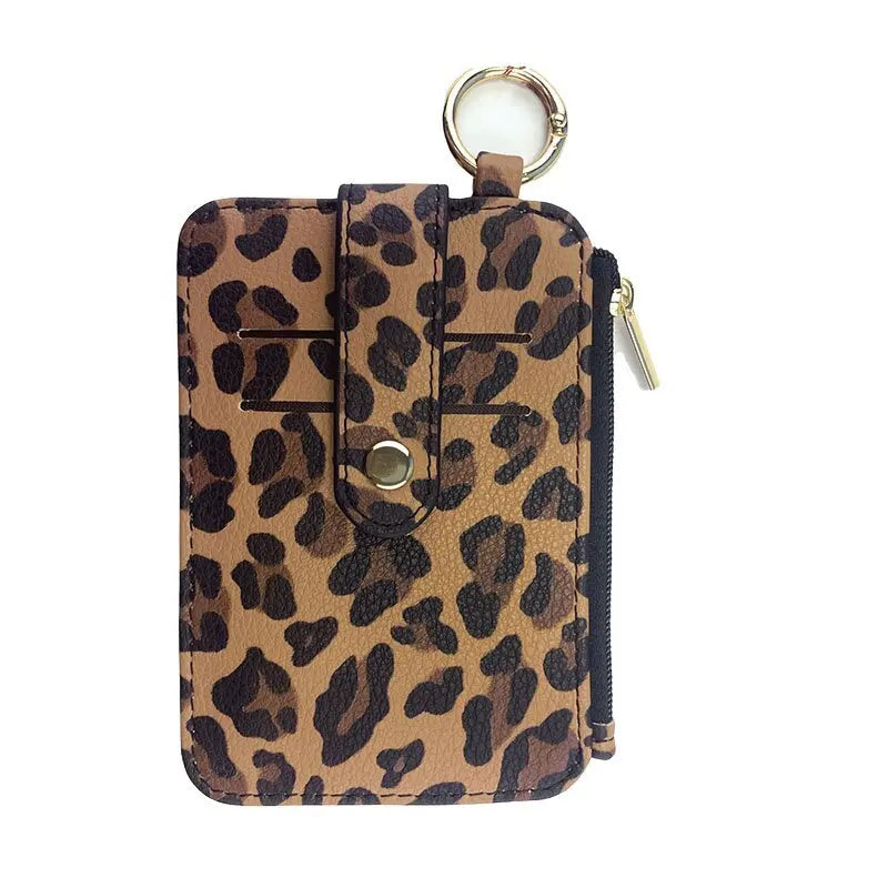 A brown leopard print PU leather card holder with a flap and coin pocket, featuring a gold-toned keychain.