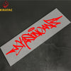 Red wildstyle graffiti text on a gray sticker placed on a dark surface.