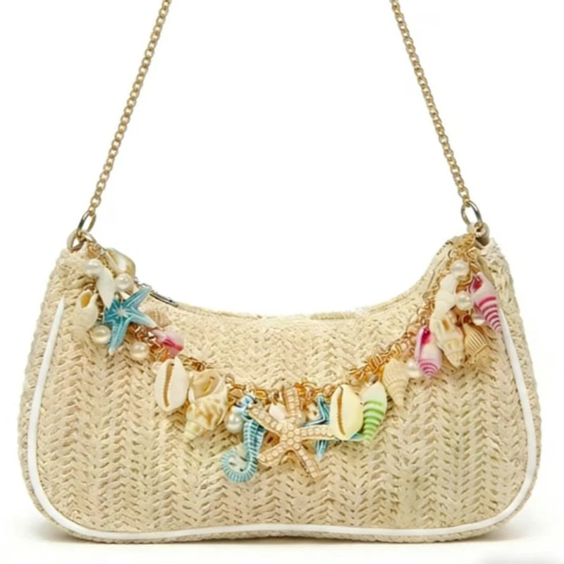 A beige straw beach shoulder bag adorned with colorful ocean shell charms.