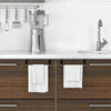 A stainless steel blender and a white towel rack are displayed above a dark wood kitchen cabinet.