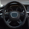 Close-up view of a black crocodile grain leather car steering wheel cover inside a vehicle