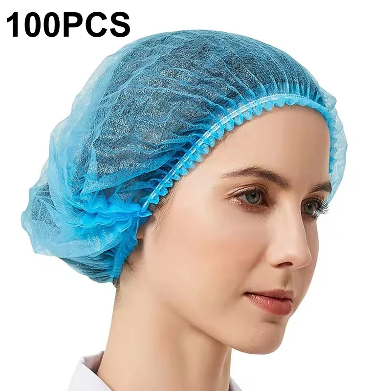 A close-up of a light blue disposable non-woven bouffant cap with an elastic band shown on a model's head.