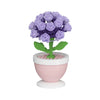A purple rose flower built from green blocks, displayed in a pink pot.