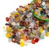 A pile of natural tumbled crystal stone chips in various colors including amber, green, brown, and clear stones.