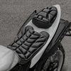 A close-up view of an ergonomic 3D motorcycle seat cushion made of black and white breathable EVA foam.