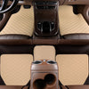 Interior view of a car with tan quilted floor mats and dark brown leather trim.