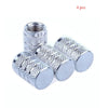 A set of four knurled aluminum tire valve caps with threaded tops shown against a white background.