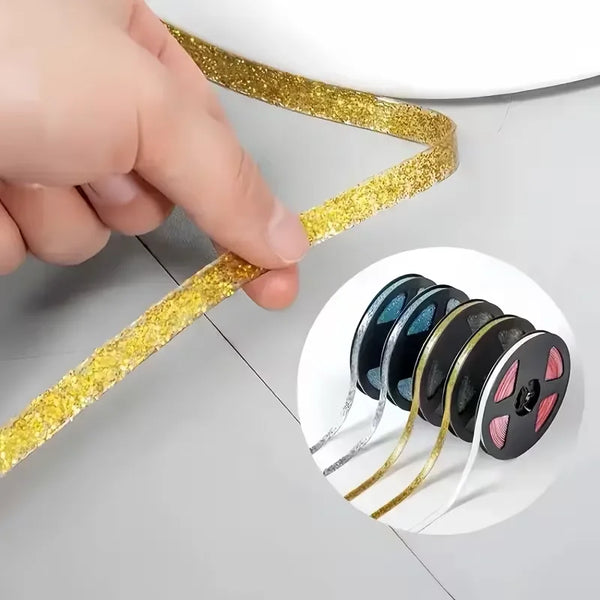 Una mano tira de una tira de sellador dorado brillante sobre una superficie, con una muestra circular de sellador de silicona