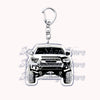 Silver metal key ring with a detailed off-road truck charm featuring a rugged vehicle face.