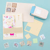 A collection of square postage stamp paper and punch cards in various pastel colors and patterns for crafting.
