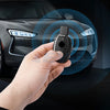 A hand holds a slim carbon fiber car key cover, demonstrating its fit for a vehicle lock.