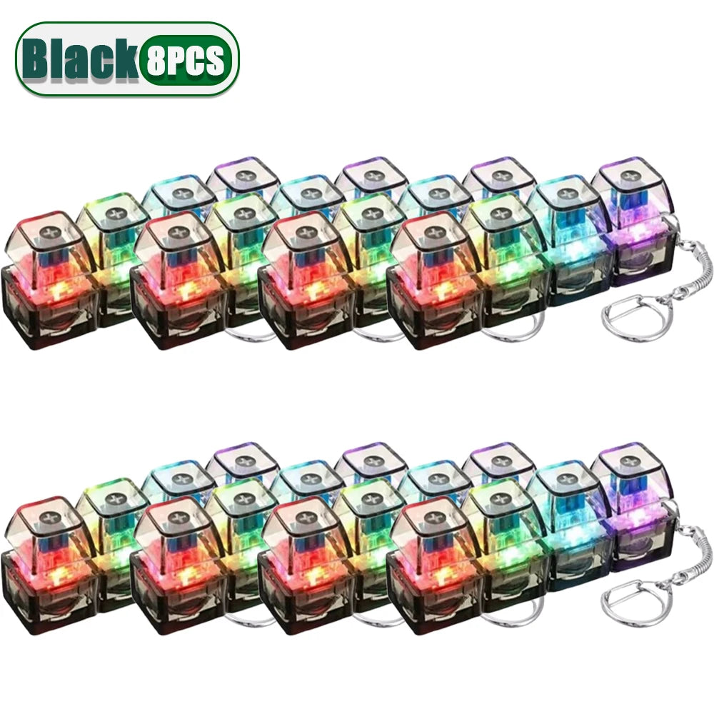 A set of eight black LED clickable fidget keychains with a keyboard design.