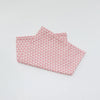 A pink soft cotton baby pillowcase featuring a geometric pattern of white triangles.