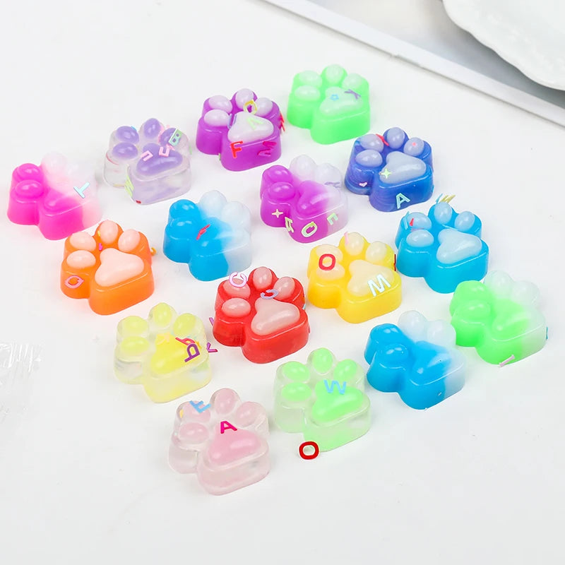 A collection of colorful squishy cat paw fidget toys in various shades of pink, purple, green, and blue.