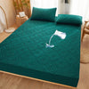 A teal quilted mattress protector with extra padding is displayed on a wooden bed frame.