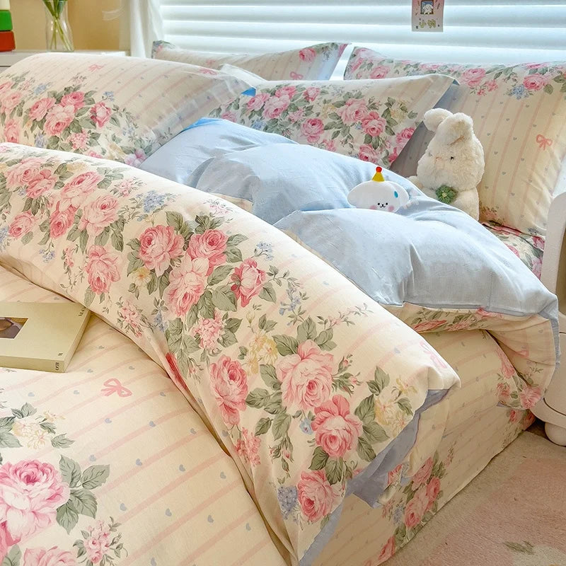 A bed dressed with a lavender floral duvet cover set featuring pink and green roses and light blue accents.