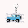 A durable metal key ring featuring a light blue off-road truck charm.