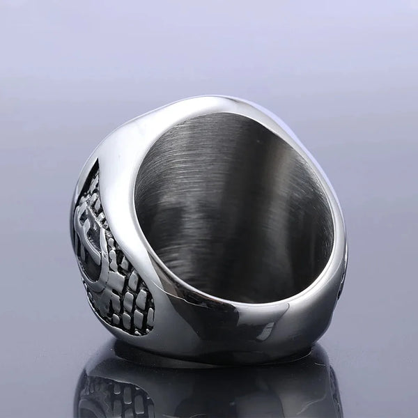 A silver men's cross signet ring with an engraved pattern, shown in a close-up view.