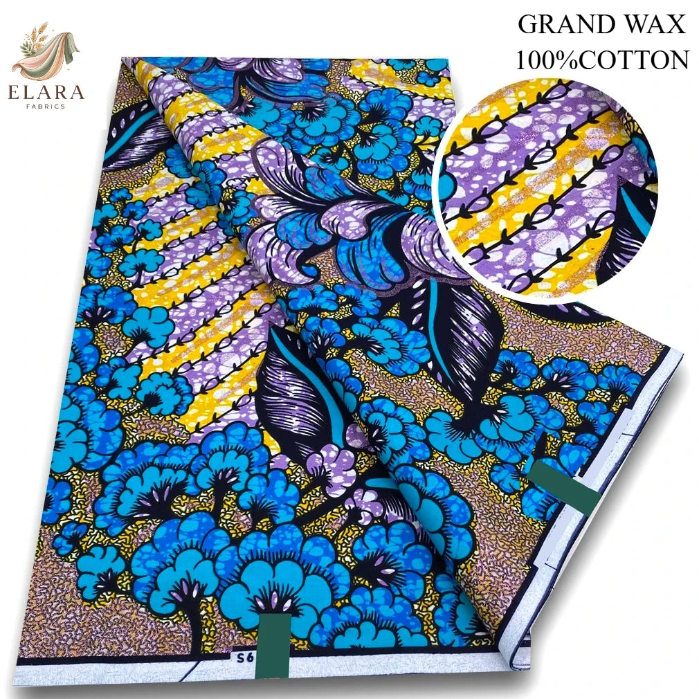 A bolt of pink glitter African wax print fabric featuring blue and yellow floral patterns.