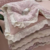 Pink floral washed cotton gauze summer quilt with white lace trim and a silver button