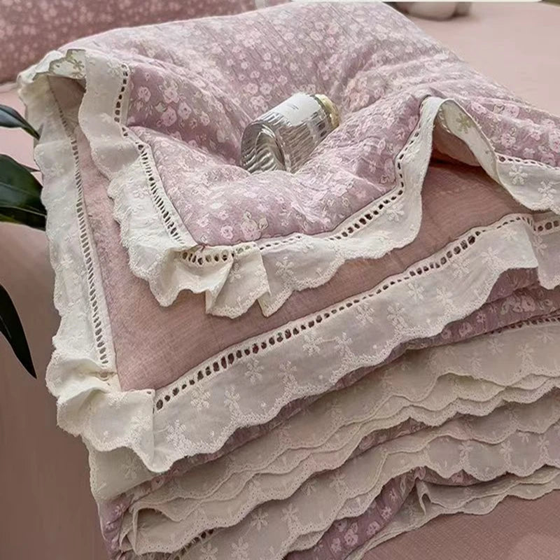 Pink floral washed cotton gauze summer quilt with white lace trim and a silver button