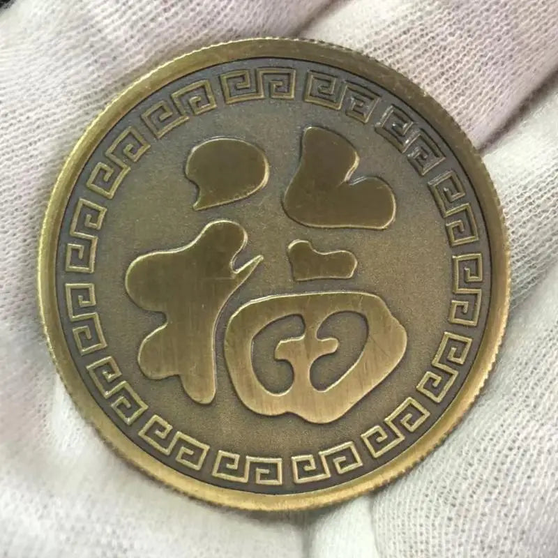 Runde, antike Goldmünze mit stilisiertem Koi-Design in geometrischer Umrandung.