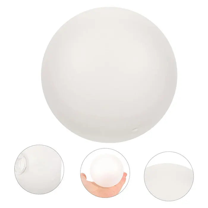 A white frosted glass dome lampshade shown from above and a hand holding it.