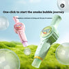 A pink and green magic smoke bubble machine is shown blowing bubbles over green grass.