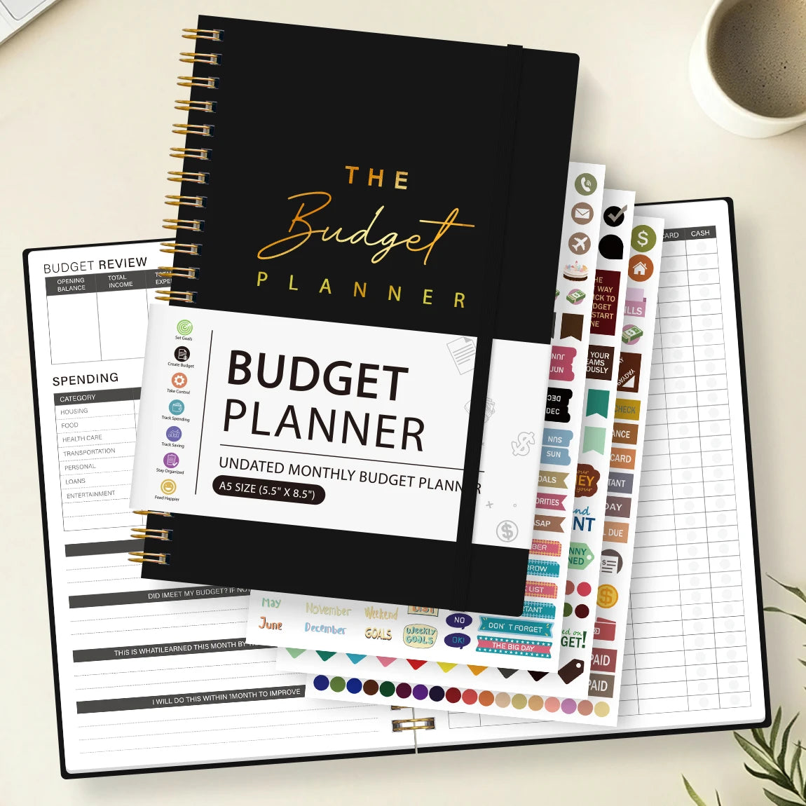 A black spiral-bound budget planner with various sheets and stickers for monthly budgeting.