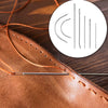 A close-up of a brown leather piece with orange thread and silver sewing needles, next to an illustration of various needles.