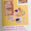 A package of oatmeal and fruit porridge ingredients with miniature food accessories for a doll kit