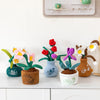 A collection of cute artificial flower plush dolls in various colors like red, pink, purple, and white, set against a white b