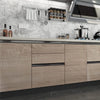 A modern kitchen featuring light wood grain cabinetry, stainless steel appliances, and a gray tiled backsplash.