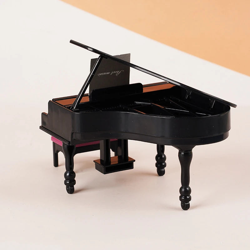 A black 1:12 scale dollhouse piano with a bench and music stand, used as miniature musical instrument decor.