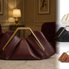 A maroon soft PU leather crossbody bag with gold hardware resting on a marble surface.