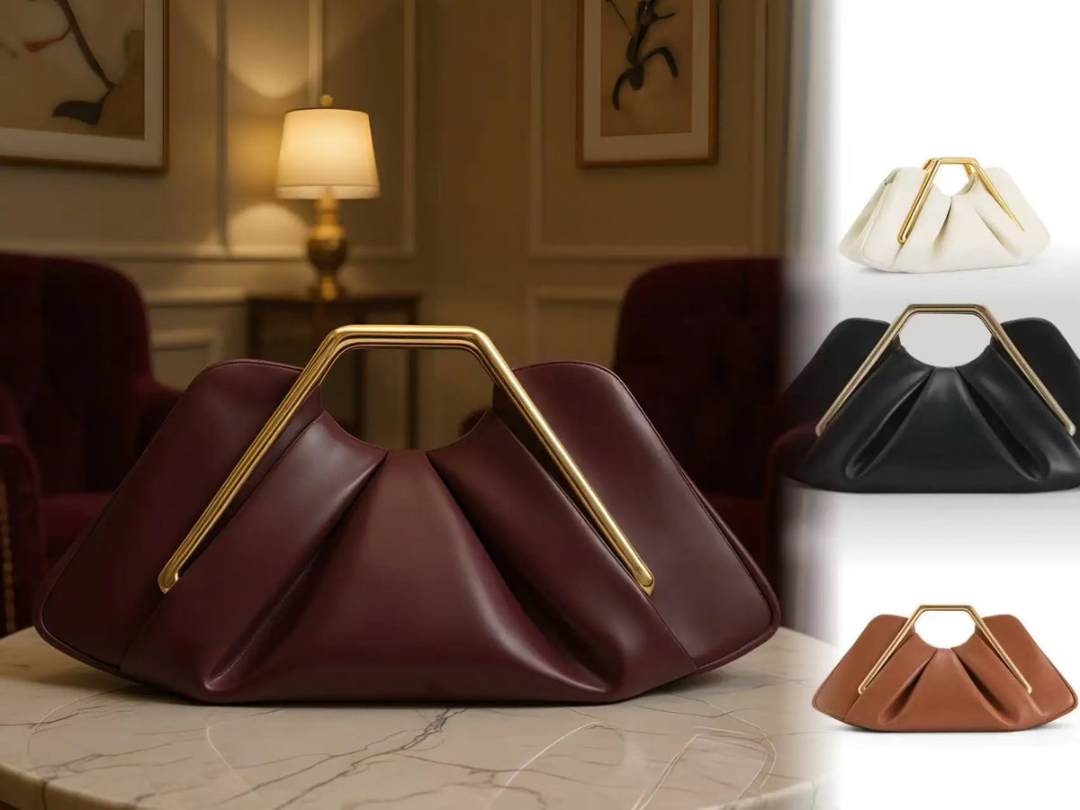 A maroon soft PU leather crossbody bag with gold hardware resting on a marble surface.