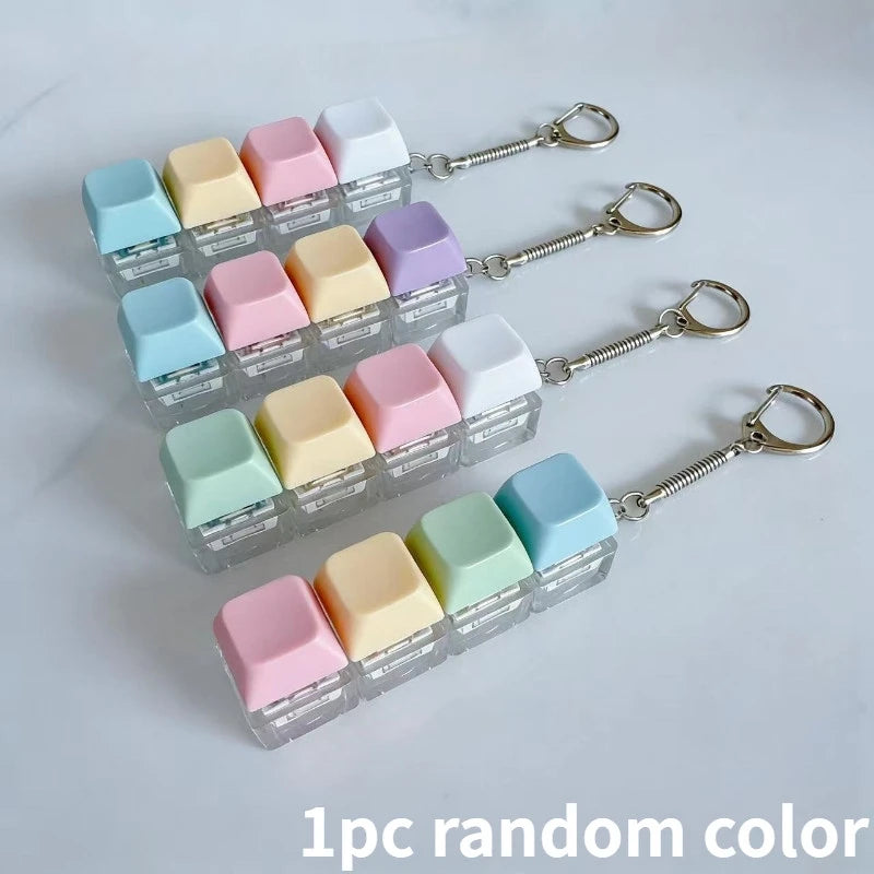 A collection of 12 colorful LED macaron keyboard fidget toys attached to silver keychain rings.